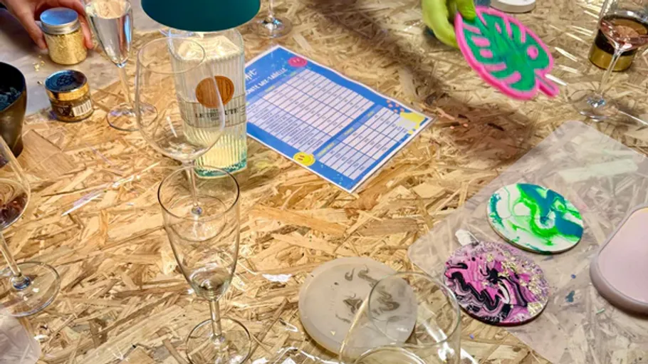 Craft table with drinks and painted coasters.