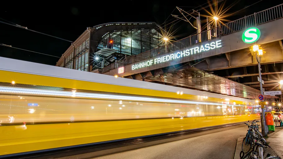 Yellow tram passing beneath Friedrichstrasse station.