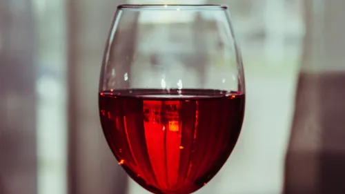 Red wine glass in a dim setting.