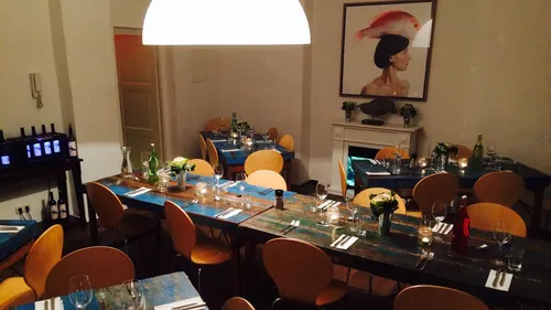 Gemütliches Restaurant mit Kerzenlicht und Kunstwerk.