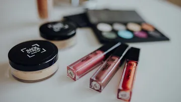 Makeup items on a white table surface.