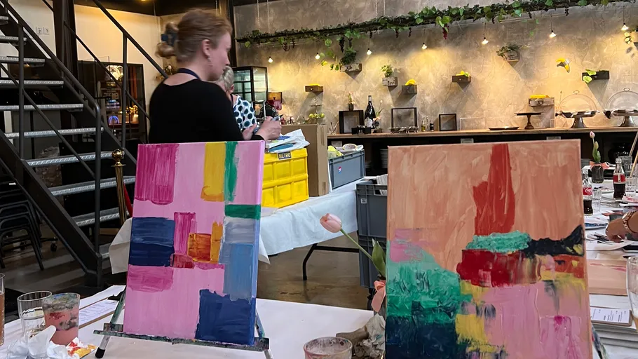 Two abstract paintings on easels in art studio.