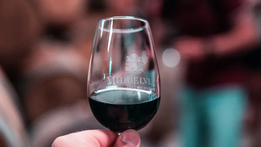 Hand holding a wine glass indoors.