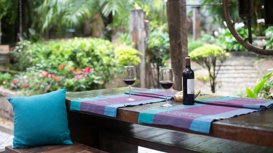 Wine bottle and glasses on garden table.