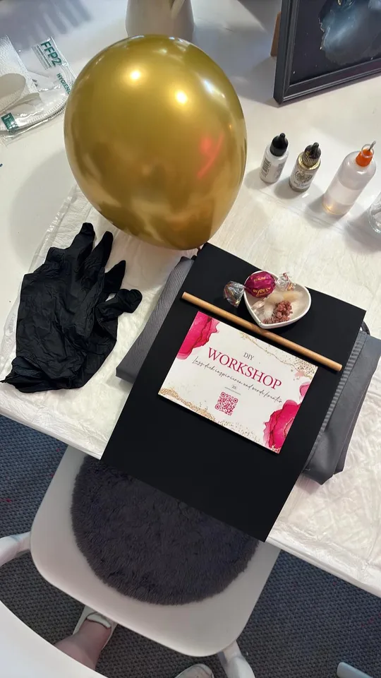 Balloon, gloves, and workshop materials on a table.