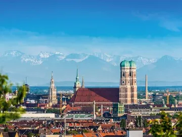 München mit Bergen im Hintergrund und klar blauem Himmel.