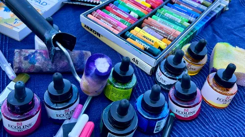 Art supplies on a blue fabric surface.