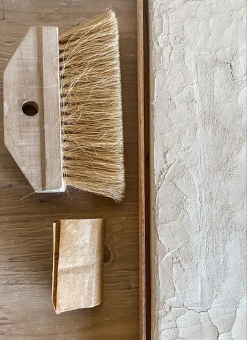 Bürste und Schleifpapier auf Holzoberfläche.