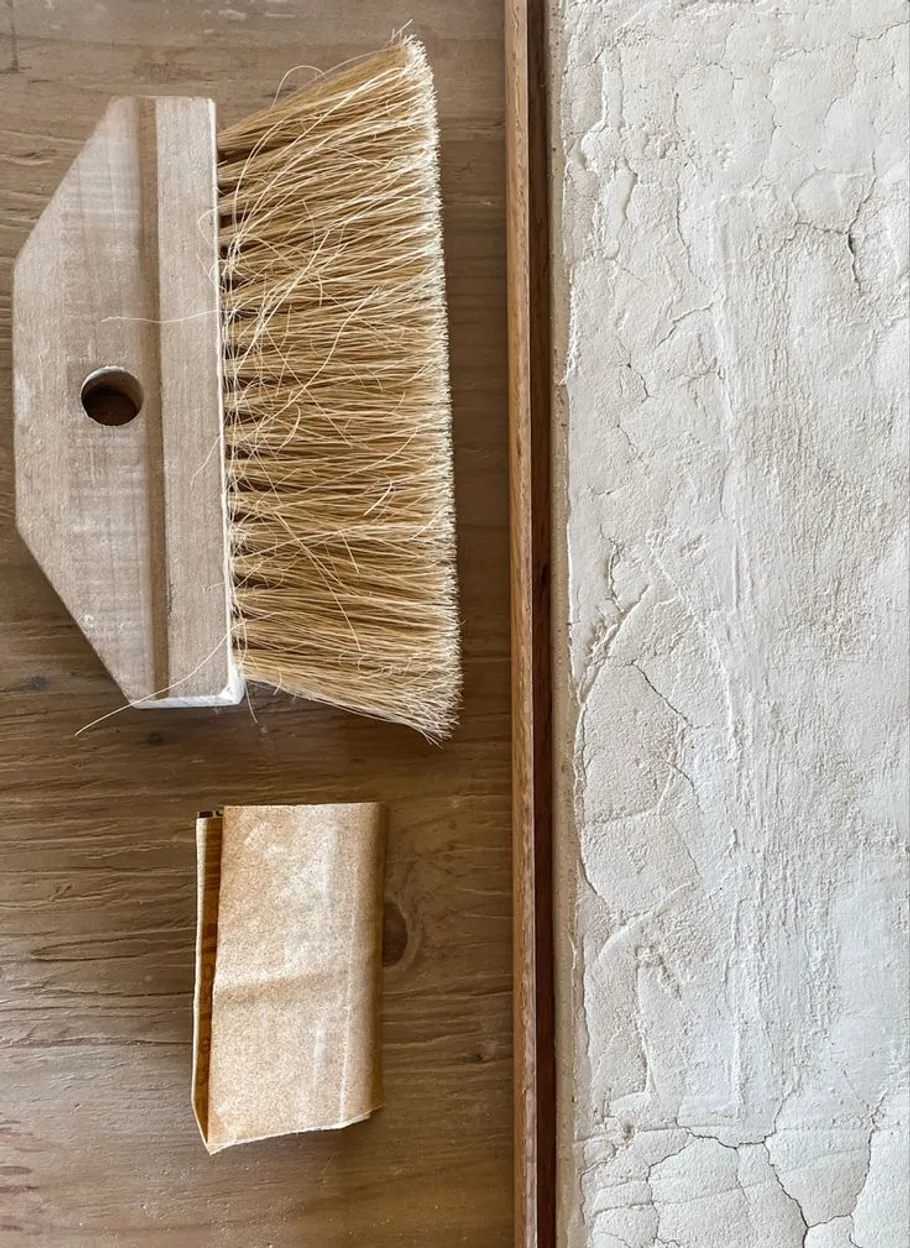 Bürste und Schleifpapier auf Holzoberfläche.