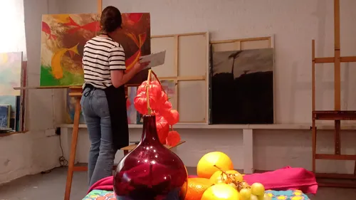 Malerin arbeitet im bunten Kunststudio.