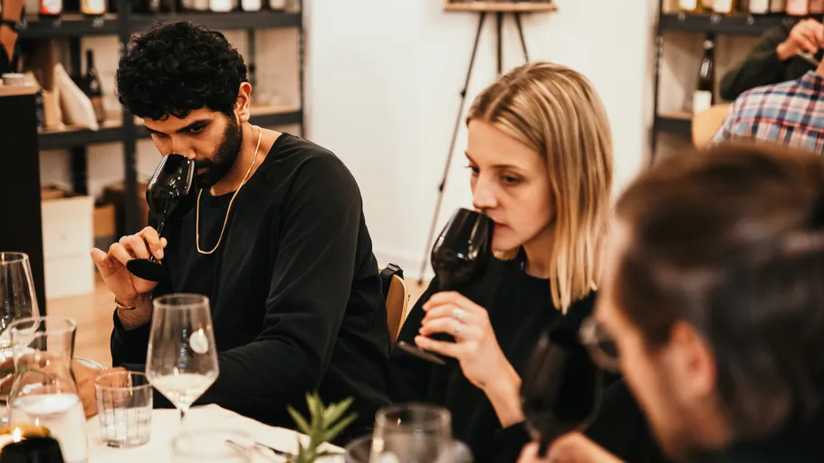 People tasting wine in a cozy setting.