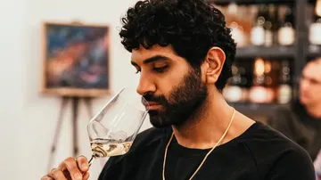 Mann riecht an Wein in einem Verkostungsraum.
