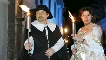 Zwei Personen mit Fackeln nachts im Freien.