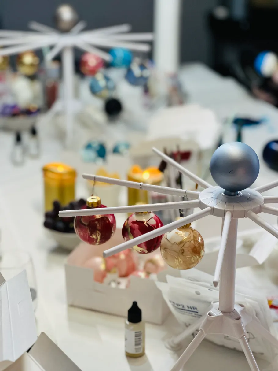 Christmas ornaments drying on stands in a workshop.