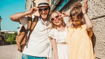 Three friends smiling outdoors in summer.