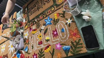 Bemalter Fußabtreter mit Blumen und Wort 'HELLO'.