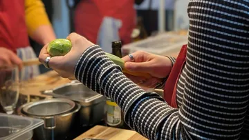 Person schält Zucchini in Küchenszene.