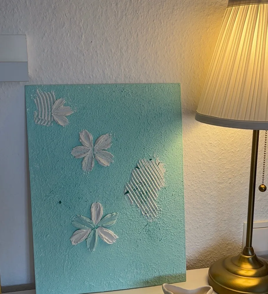 Strukturierte Malerei neben einer Tischlampe.
