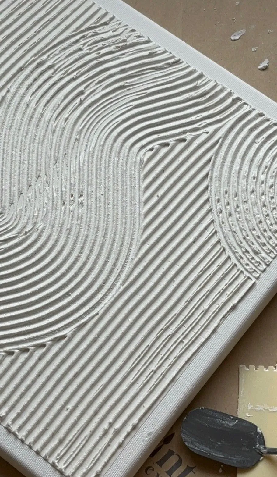 Strukturierte Leinwand mit weißen Linien, Werkzeuge nahbei.