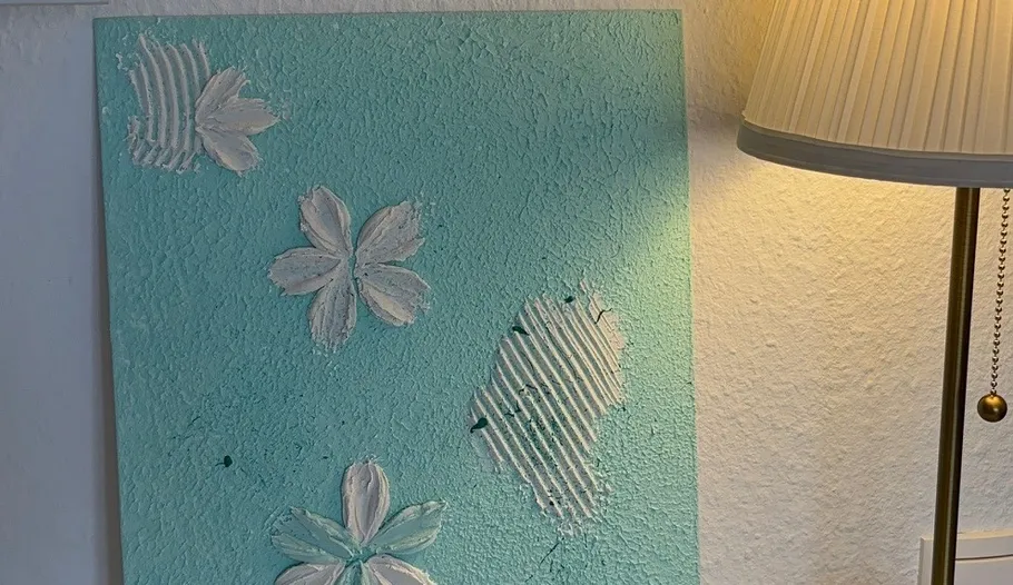 Texturiertes Blumenbild neben einer Lampe.