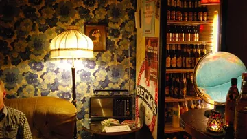 Vintage room with lamp, globe, and fridge.