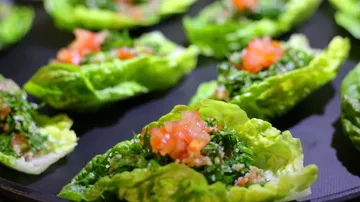 Lettuce cups filled with salad on a tray.