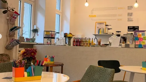 Buntes Café-Innendekor mit Kunstbedarf und Blumen.
