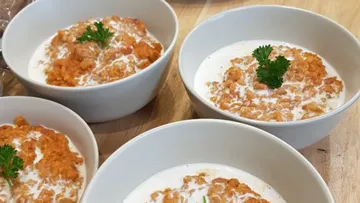 Vier Schalen mit cremiger Linsensuppe, garniert mit Petersilie.