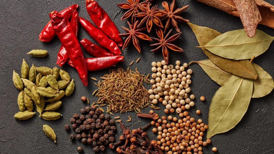 Assorted spices on dark surface.