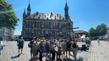 Gruppe posiert vor historischem Gebäude.