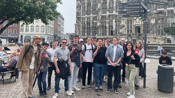 Group standing in European city square.