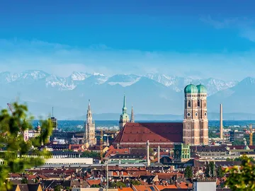 View of Munich's skyline with mountains in the background.