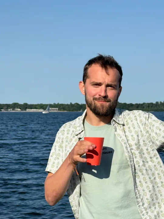Man holding red cup by the water.