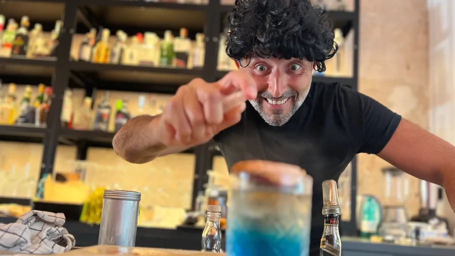 Mann zeigt begeistert auf Getränk in Bar.
