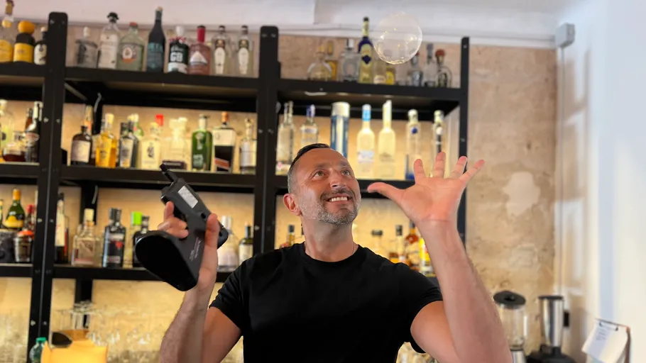 Mann bläst Dampfblase in einer Bar.