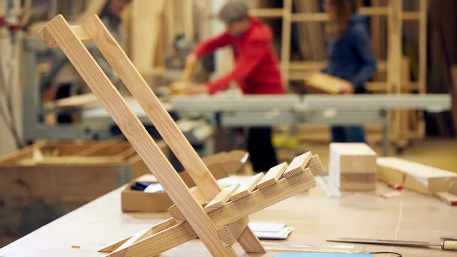 Wooden stand on table, people working background.