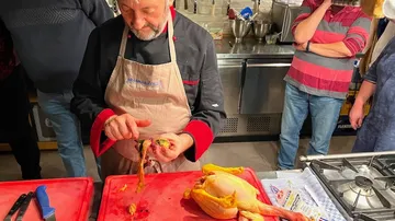 Koch bereitet Huhn in einer Küchenszene vor.