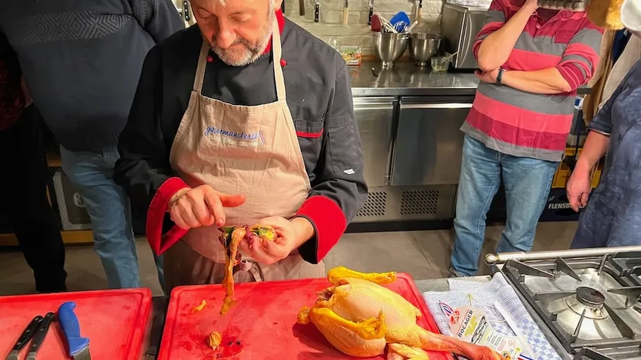 Koch bereitet Huhn in einer Küchenszene vor.