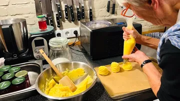 Person spritzt Teig in einer Küche.