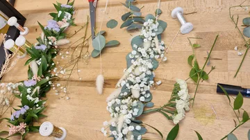 Florale Anordnung in Arbeit auf Holztisch.