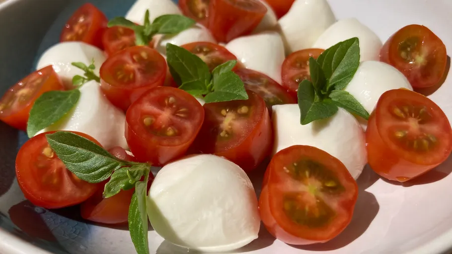 Caprese-Salat mit Tomaten und Mozzarella auf Teller.