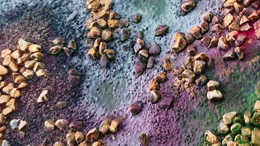 Colorful pebbles scattered on textured ground.