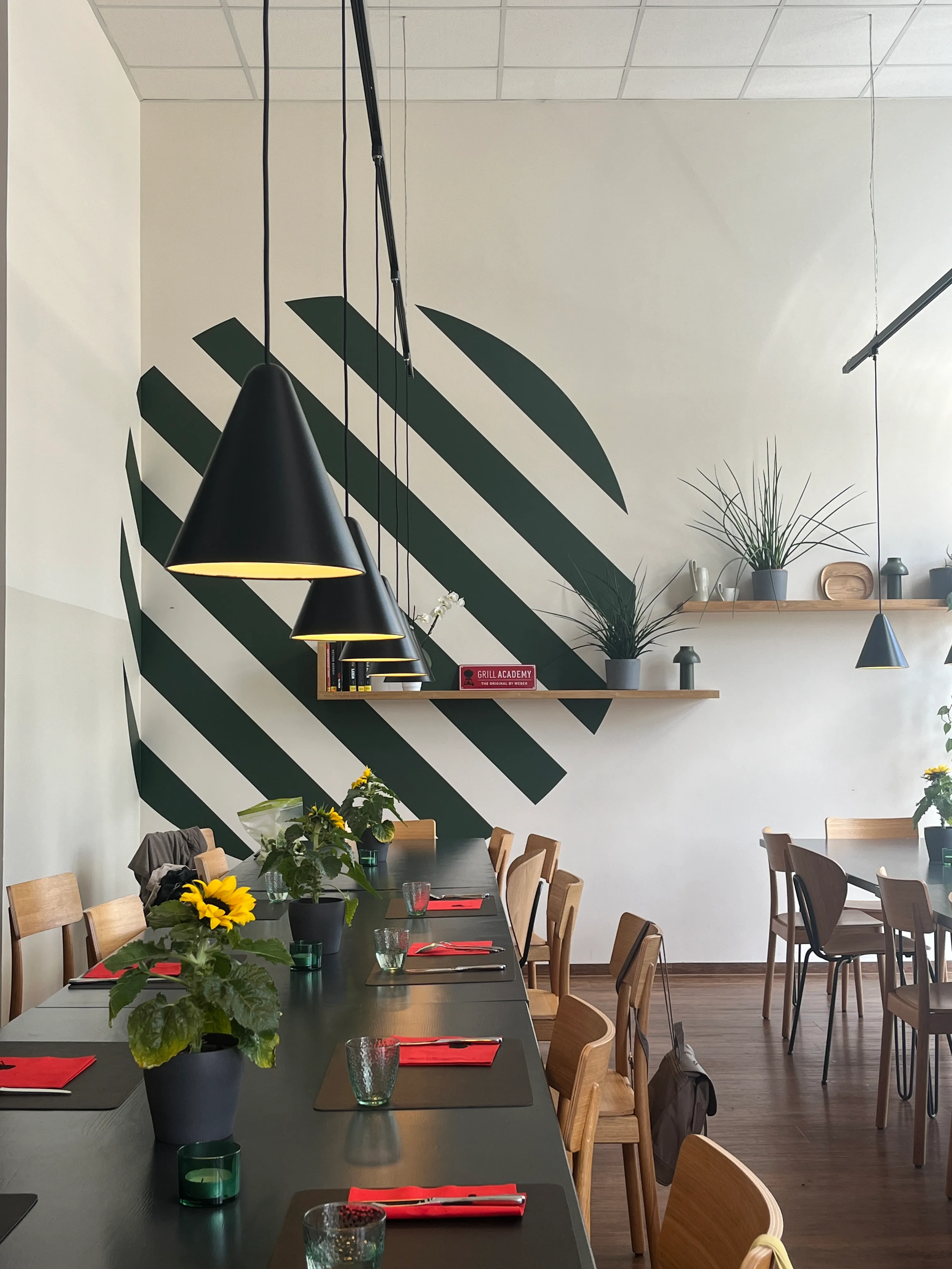 Restaurant-Innenraum mit Pflanzen und Hängeleuchten.