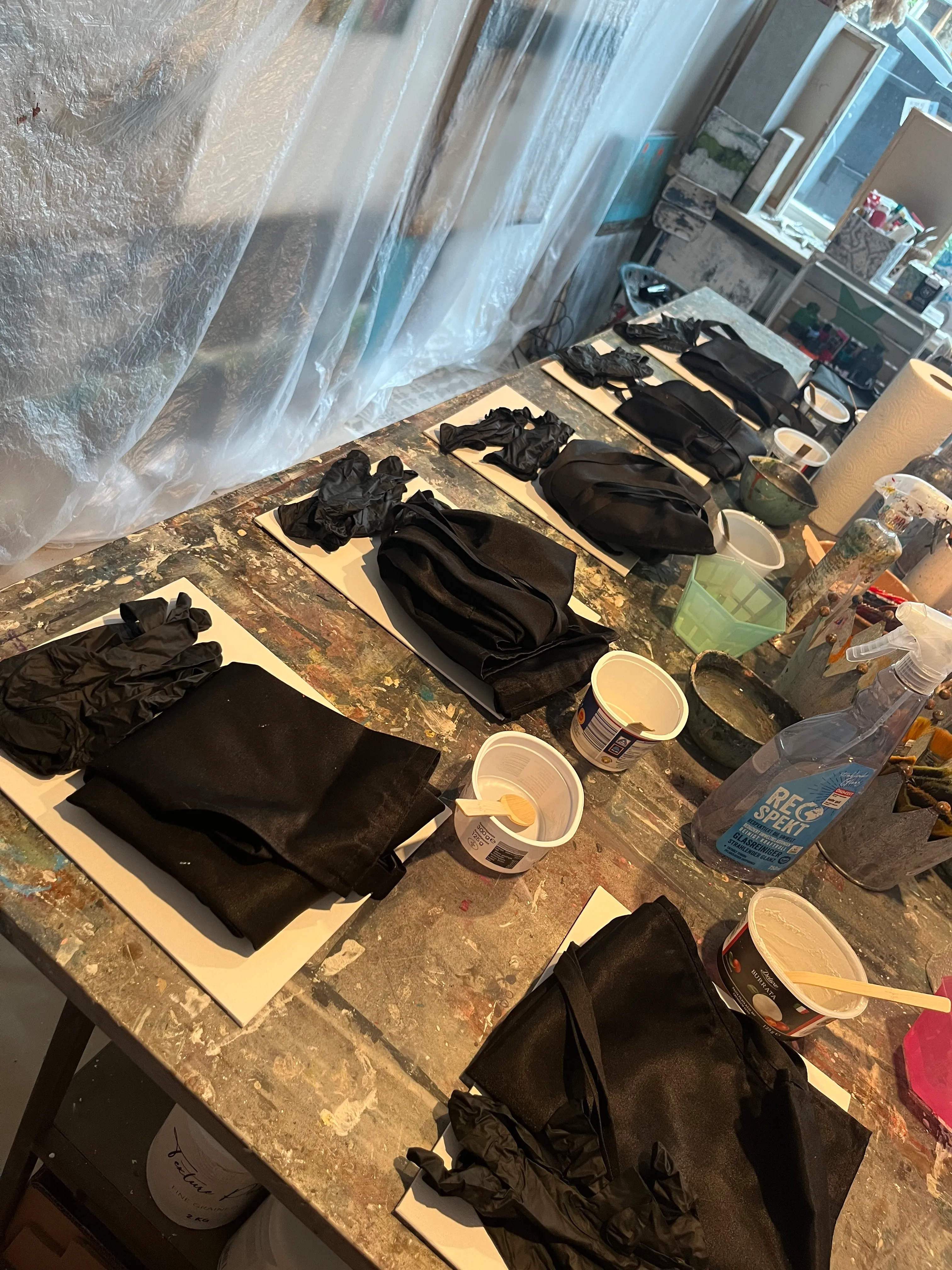 Schwarze Tücher und Handschuhe auf Werkbank.