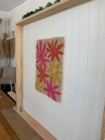 Colorful floral rug on wooden frame.