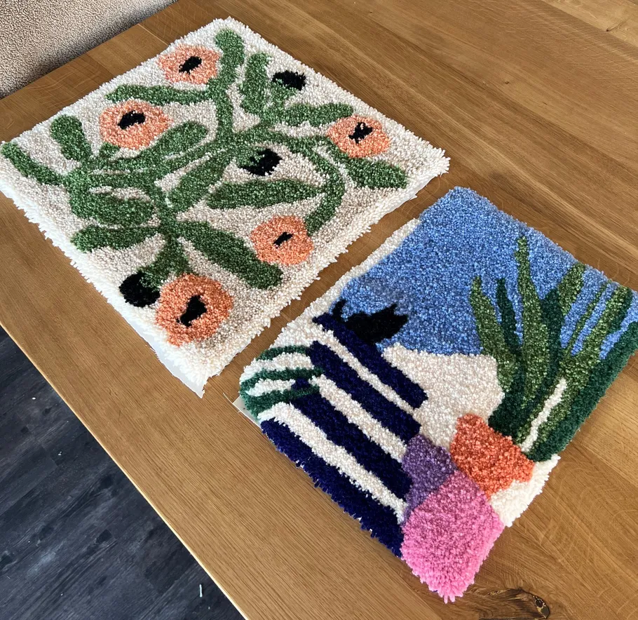 Zwei bunte getuftete Teppiche auf Holztisch.