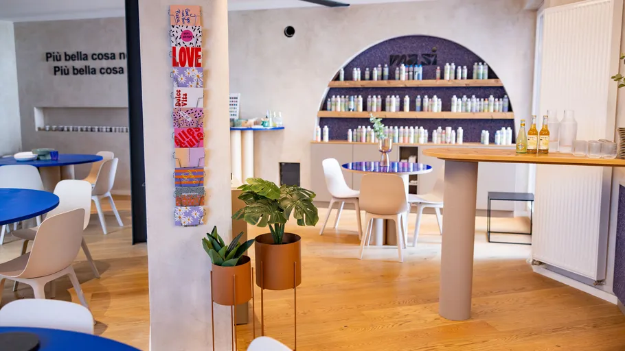 Modernes Café-Interieur mit blauen Tischen und weißen Stühlen.