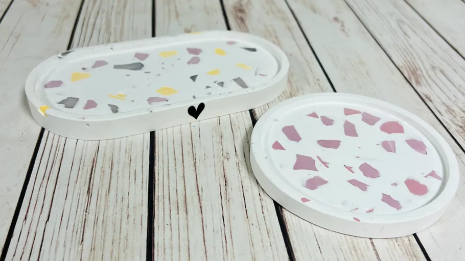 Zwei Terrazzo-Tabletts auf Holzoberfläche.