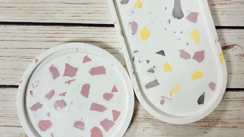Terrazzo-patterned trays on wooden surface.