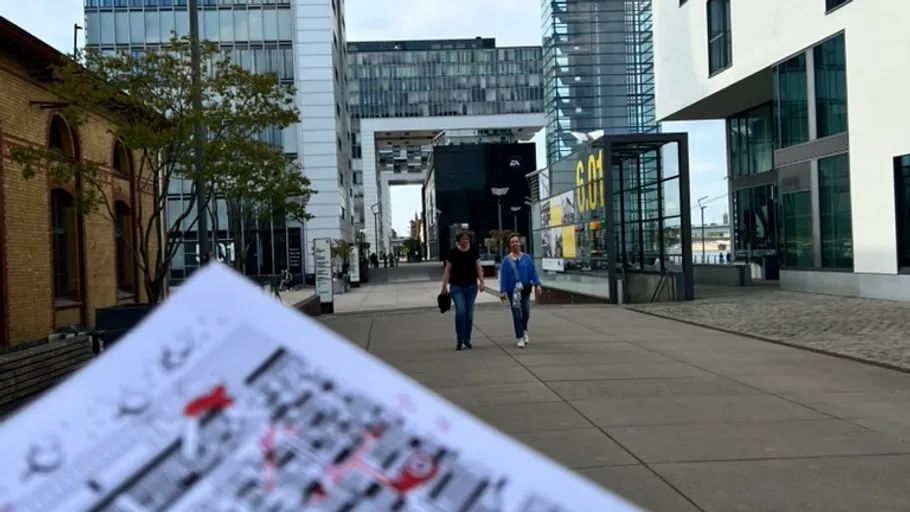 Menschen spazieren auf moderner Stadtstraße.